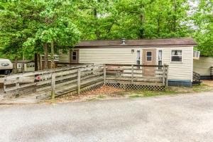a house with a wooden fence next to a road at Williamsburg Camping Resort Wheelchair Accessible Park Model 7 in Croaker