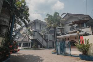 a street with palm trees and a building at RedDoorz Plus near Pelabuhan Merak in Cilegon