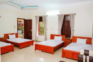 1 Schlafzimmer mit 3 Betten und einem Deckenventilator in der Unterkunft Homestay Xuandung in Ninh Bình