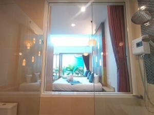 uma casa de banho com uma janela e uma cama em เดอะชาลี The Charlie em Nan