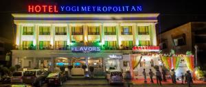 un hotel con un'insegna al neon di fronte a un edificio di Yogi Metropolitan Hotel a Navi Mumbai