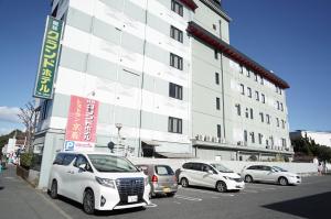 a parking lot with cars parked in front of a building at 館林グランドホテル in Tatebayashi