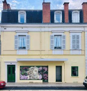 un edificio con un mural en el costado en Le Massilia comble en Vichy