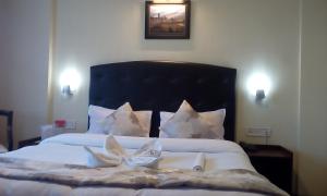 Un pat sau paturi într-o cameră la SANDRUP HOTEL