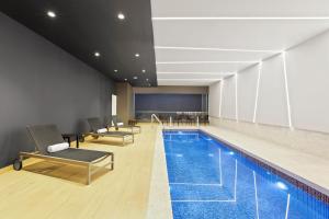 una piscina en una habitación de hotel con sillas y mesa en Holiday Inn Express - Lima San Isidro, an IHG Hotel en Lima