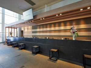 a waiting area of a restaurant with benches and flowers at Sotetsu Grand Fresa Tokyo-Bay Ariake in Tokyo