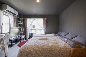1 dormitorio con 1 cama grande y TV en Akabane TK Building 201, en Tokio