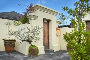 uma casa branca com uma porta e algumas plantas em Komaneka at Rasa Sayang Ubud em Ubud