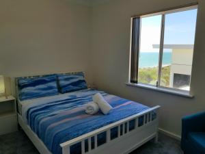 A bed or beds in a room at Caravel Beach House Mandurah