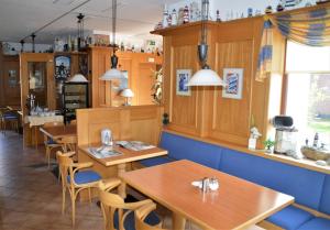 a dining room with wooden tables and chairs at Hotel Südstrand Amrum in Wittdün
