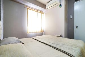 sypialnia z dużym łóżkiem i oknem w obiekcie Apartment Kalibata City by Novi w Dżakarcie