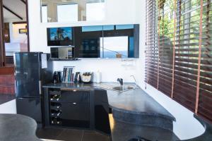 a kitchen with a sink and a black refrigerator at Horizon Luxury Pool Villas Koh Tao in Koh Tao