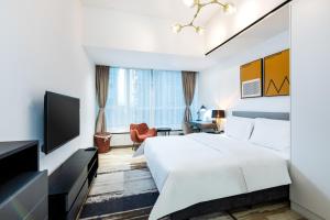 Una televisión o centro de entretenimiento en Golden Central Hotel Serviced Residence-Xin Hao E Du金中环服务公寓新浩e都店