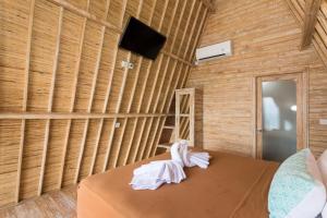 a room with a bed with a wall of wood at The Dewi Sun Sun Nusa Penida in Nusa Penida