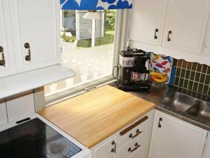 a kitchen with white cabinets and a wooden counter top at 6 person holiday home in L derup in Löderup
