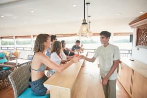 a group of people shaking hands at a kitchen counter at Charter by DAE - Luxury River Cruise in Madapata