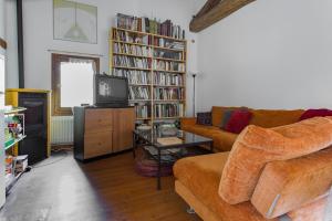 a living room with a couch and a tv at La Villa delle Rose near Venice in Trebaseleghe