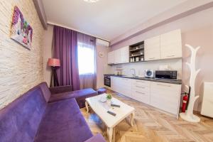 a living room with a purple couch and a table at Sofia Violet Life Apartment in Sofia