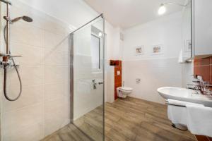 een badkamer met een douche, een wastafel en een toilet bij Pension Gschaider in Payerbach