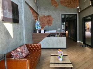 uma sala de estar com um sofá de couro e uma mesa em The New Residence Buriram em Buri Ram