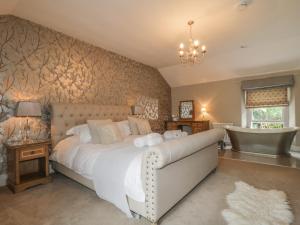 ein Schlafzimmer mit einem großen Bett und einem Kronleuchter in der Unterkunft Stair Cottage in Keswick