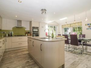 eine Küche mit weißen Schränken und einem Tisch mit Stühlen in der Unterkunft Stair Cottage in Keswick