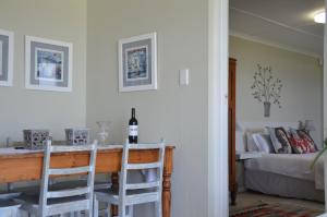 a room with a table and two chairs and a bed at Beach Villa Apartment in Hermanus