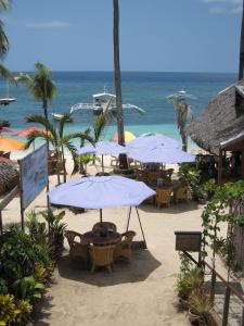 a group of tables and umbrellas on the beach at Hayahay Resort in Panglao