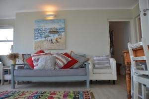 a living room with a couch and a chair at Beach Villa Apartment in Hermanus