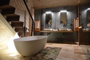 a large bathroom with two sinks and a tub at Gatto Bianco Case d'Allora in Alberobello