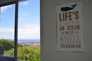 a sign that reads lifes at last with an ocean and a bigger swimin at Beach Villa Apartment in Hermanus