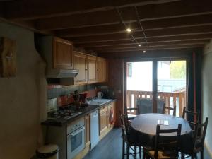 a kitchen with a table and chairs and a window at chez Mancha fave in Saint-Chaffrey