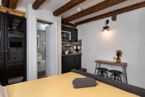 a bedroom with a yellow bed and a kitchen at Private Accommodion Linda Studio in Dubrovnik