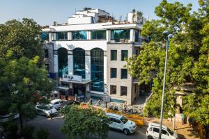 un edificio con auto parcheggiate di fronte di IKHAYA HOTELS a Nuova Delhi