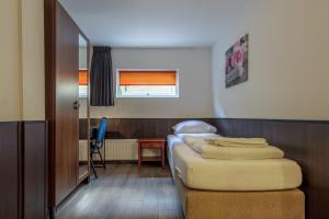 a bedroom with a bed and a desk at Hotel Randenbroek in Amersfoort