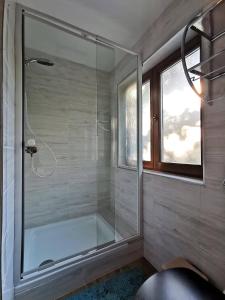 y baño con ducha y puerta de cristal. en Vaskúti Faház, en Matraszentistvan