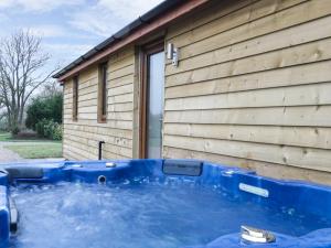 a hot tub in front of a house at Woodman's Lodge in Nantwich