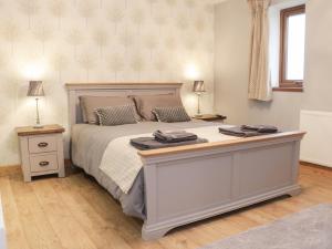 una camera da letto con un grande letto con due lampade sopra di Woodman's Lodge a Nantwich