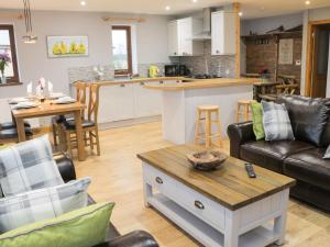 a living room with a couch and a table at Woodman's Lodge in Nantwich