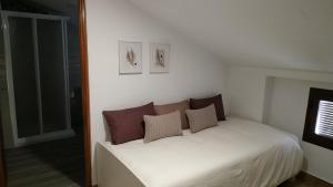 a bedroom with a white bed with pillows on it at CASA EL REMANSO DE ZUHEROS in Zuheros