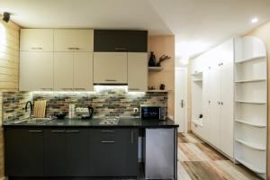 a kitchen with white cabinets and a black counter top at New Gudauri Loft2 #433 in Gudauri