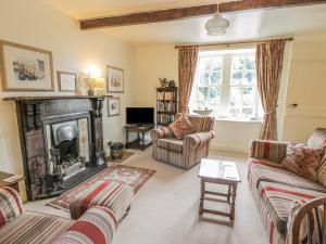 a living room with two couches and a fireplace at Near Bank Cottage in Eyemouth