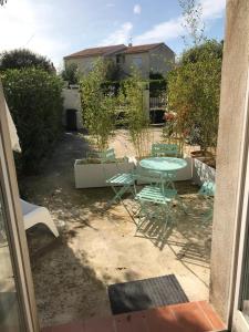 eine Terrasse mit einem Tisch und Stühlen im Hof in der Unterkunft Plan de Cuques T2 in Marseille