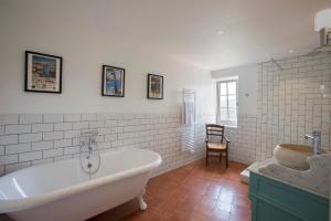 een badkamer met een bad en een wastafel bij Chateau Olmet in Lodève