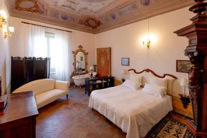 a bedroom with a king sized bed and a couch at Resort a Palazzo B&B in Fermo