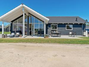 a blue house with glass windows and a patio at 10 person holiday home in Hasselberg in Kappeln