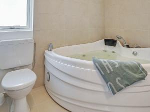 een badkamer met een wit bad en een toilet bij 10 person holiday home in Hasselberg in Kappeln