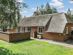 an old brick house with a thatched roof at 12 person holiday home in V ggerl se in Marielyst