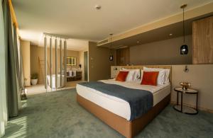 um quarto grande com uma cama grande com almofadas laranja em Wave Resort - Ultra All Inclusive em Pomorie