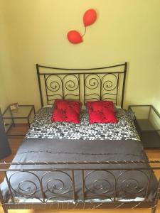 1 cama con 2 almohadas rojas y un globo en la pared en Apartament PIĘKNA, en Varsovia